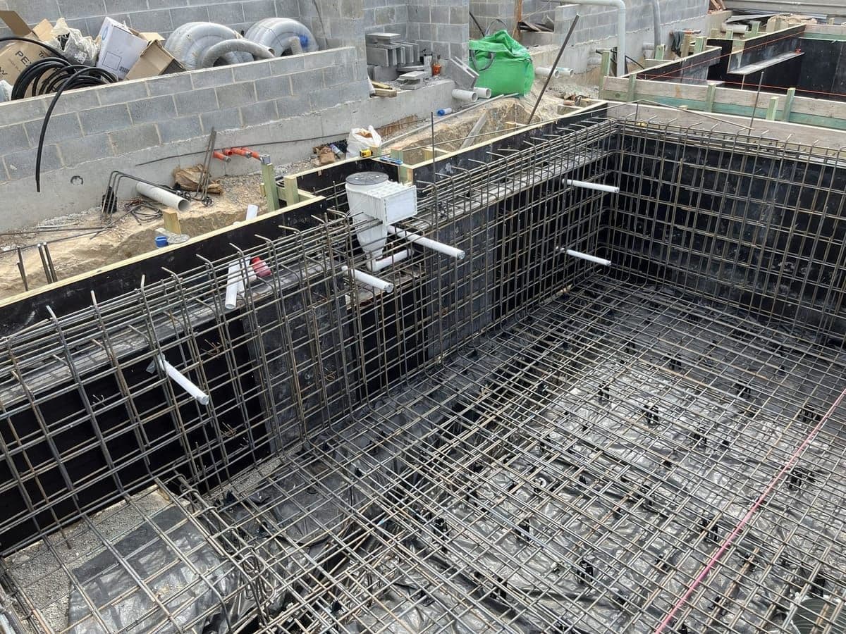 New concrete pool shell under construction, with the steel reinforcement cage and plumbed skimmer box in place before shotcrete